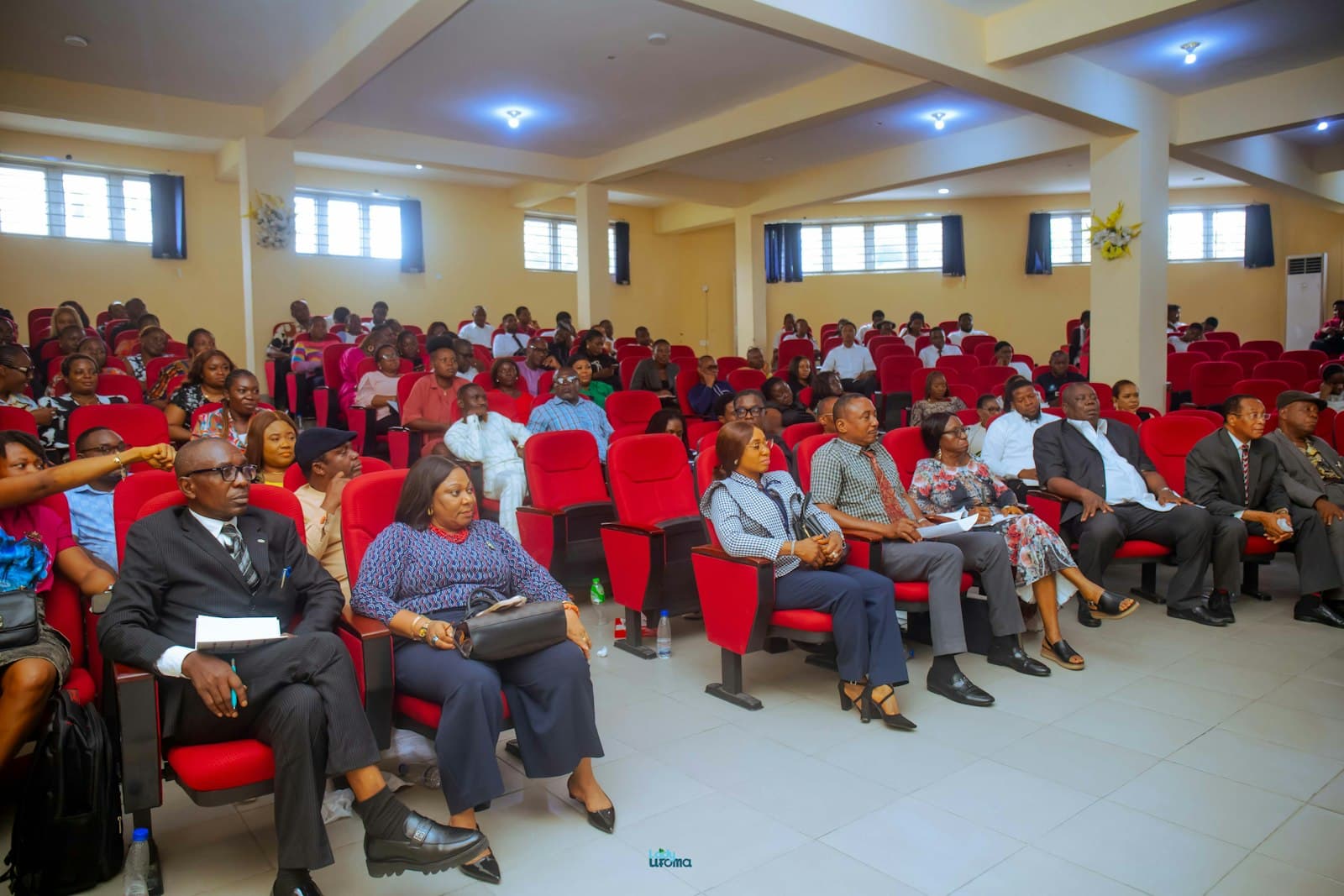 People attending a conference in a large auditorium