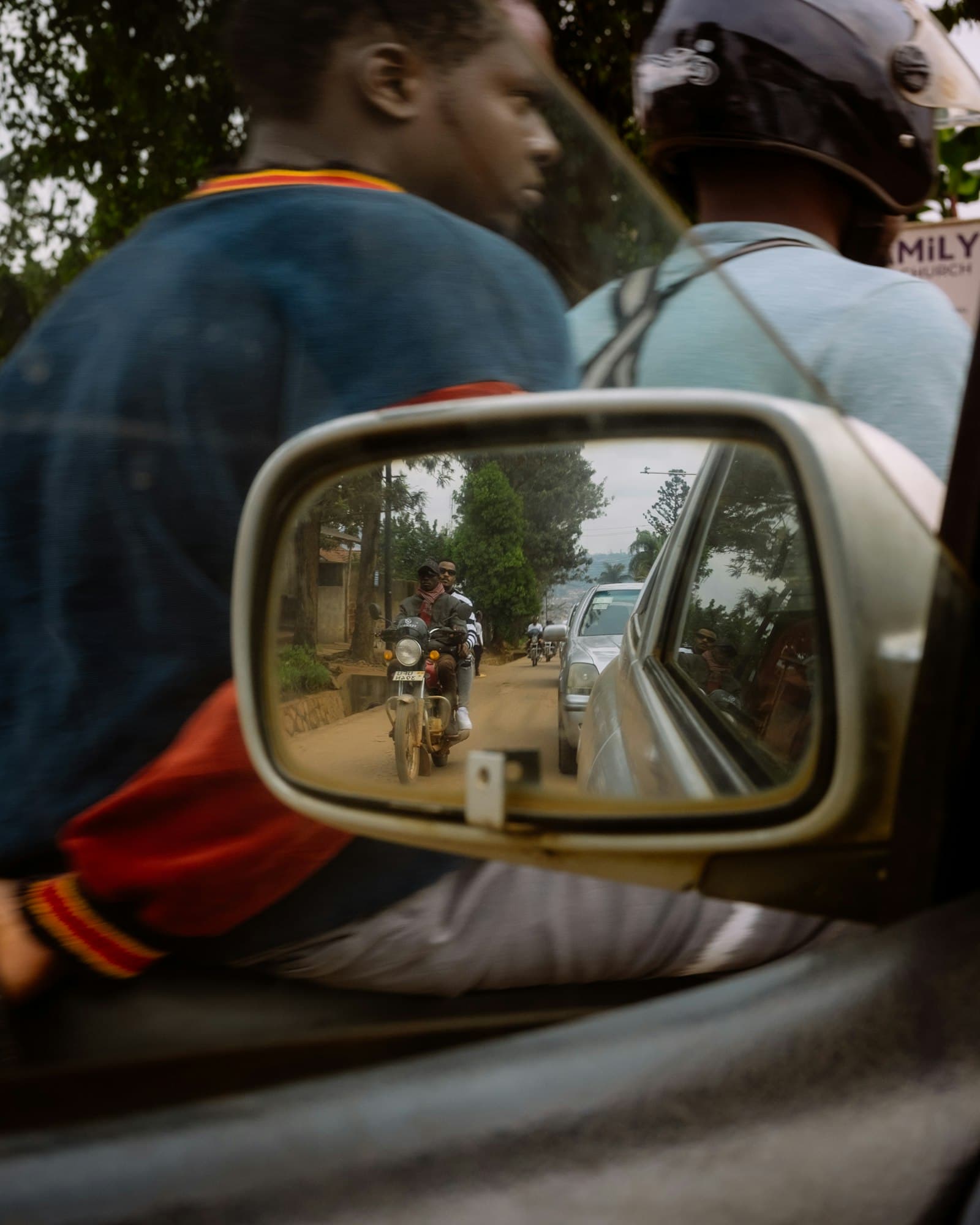 A motorcycle rider seen in a car side mirror